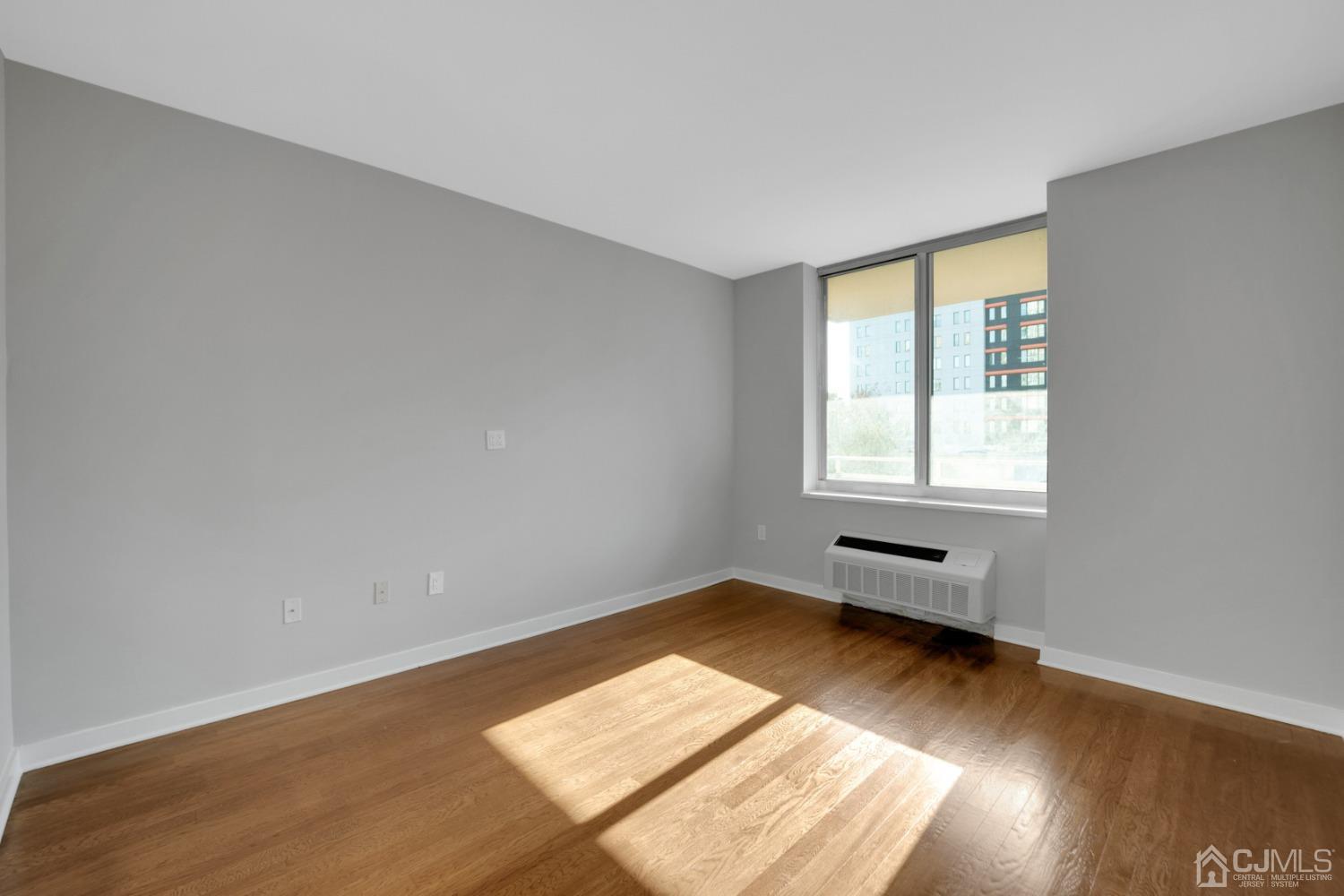 301 Hudson Park Edgewater, NJ 07020 - Photo 25 of 44 an empty room with wooden floor and windows