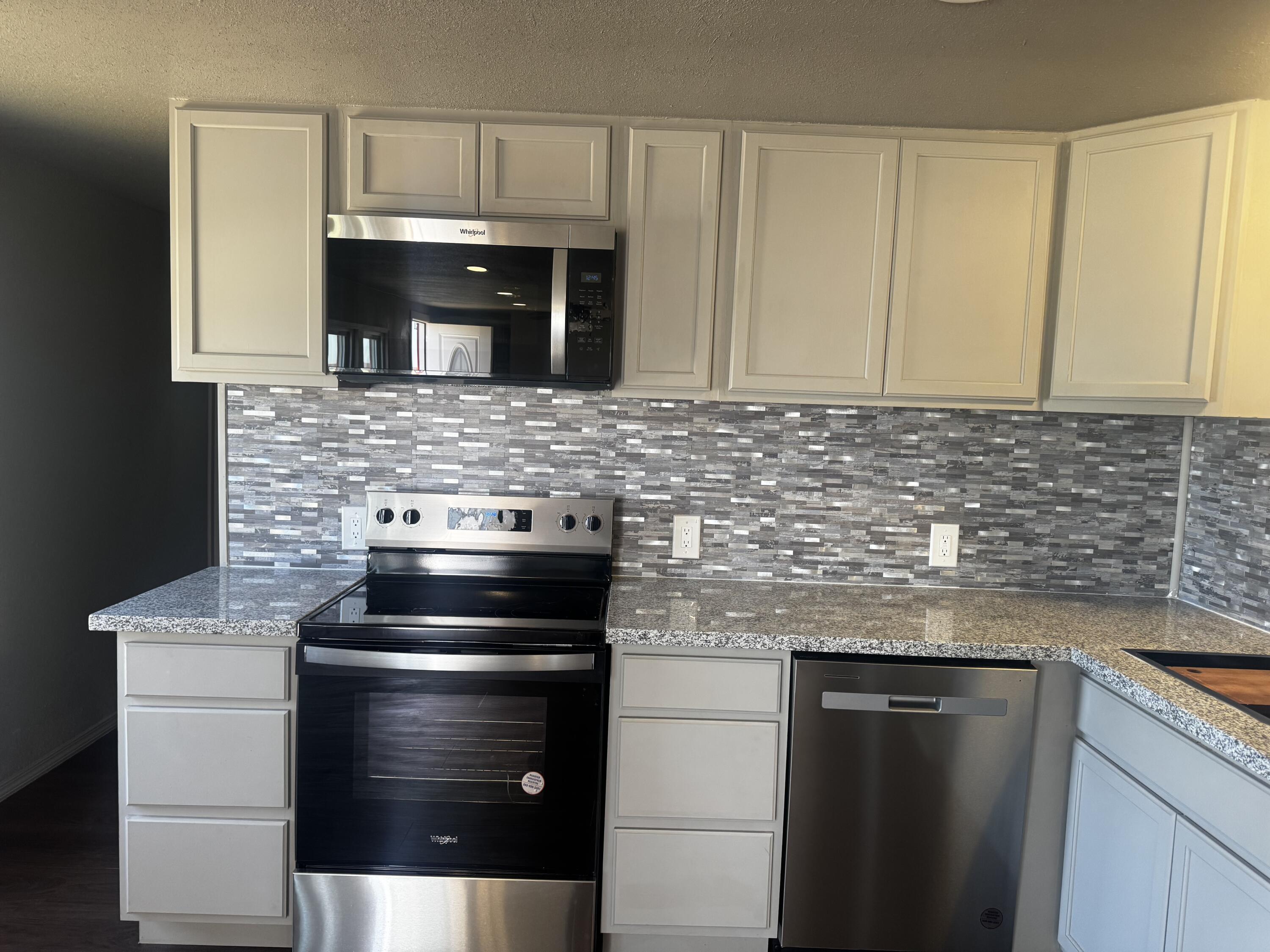 1128 Alaska Road Levelland, TX 79336 - Photo 8 of 20 a kitchen with stainless steel appliances granite countertop a stove and a microwave