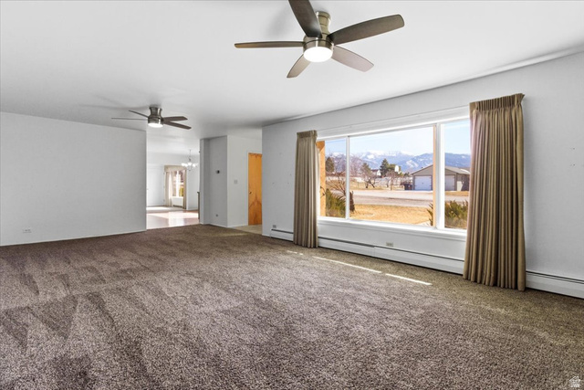 217 East 400 South Spring City, UT 84662 - Photo 15 of 71 Unfurnished room with a ceiling fan, carpet flooring, a baseboard radiator, and a mountain view