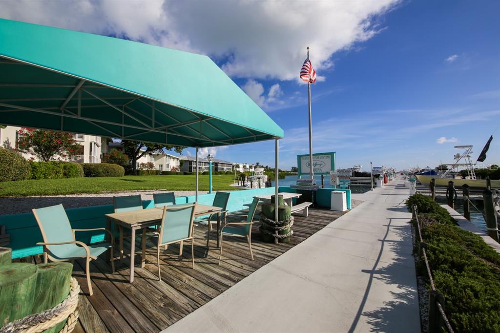 5820 Gasparilla Road, Unit SLIP 29 Boca Grande, FL 33921 - Photo 6 of 22 a view of a patio with a table chairs and a patio