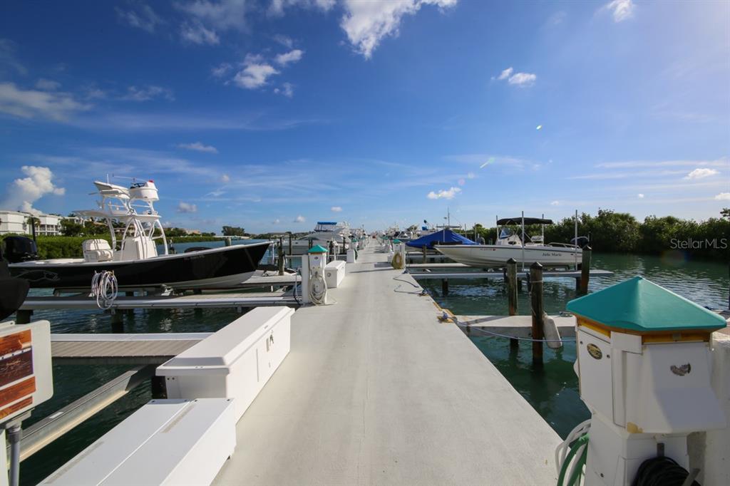 5820 Gasparilla Road, Unit SLIP 29 Boca Grande, FL 33921 - Photo 8 of 22 a view of a balcony with wooden floor and outdoor seating