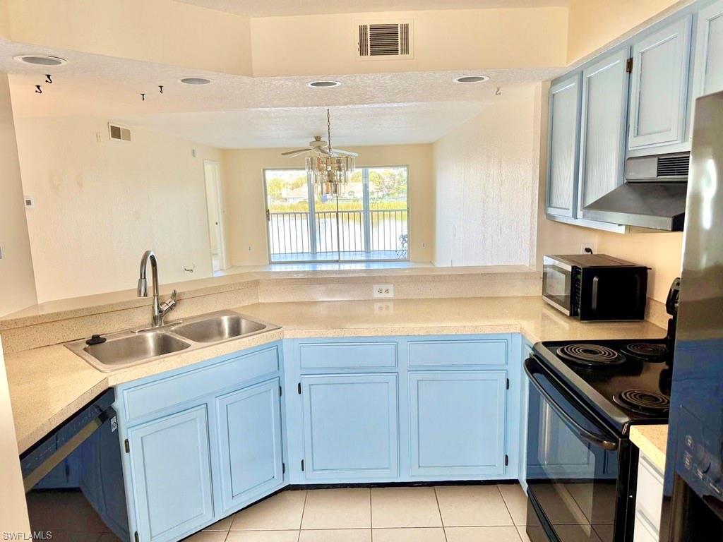 9580 Victoria Lane, Unit A202 Naples, FL 34109 - Photo 6 of 18 a kitchen with a sink stove and cabinets