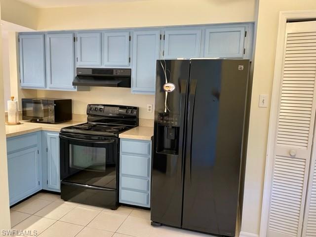 9580 Victoria Lane, Unit A202 Naples, FL 34109 - Photo 8 of 18 a kitchen with a refrigerator stove and cabinets