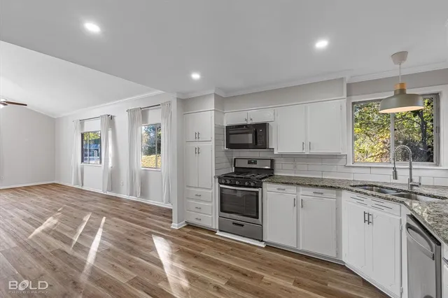 a kitchen with stainless steel appliances granite countertop a stove a sink and a refrigerator