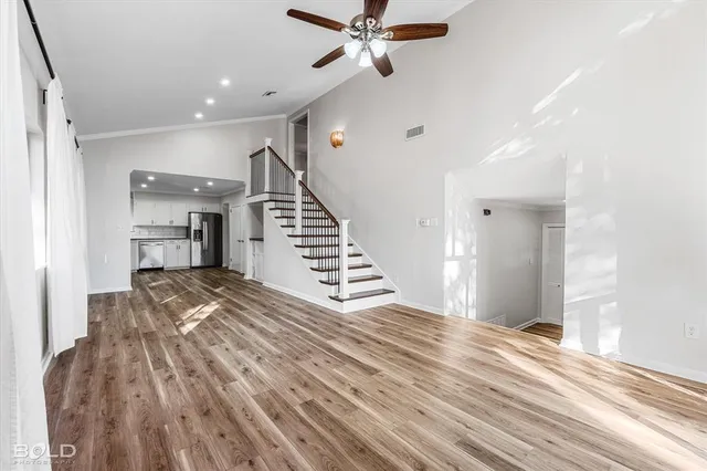 a view of a living room with wooden floor and staircase