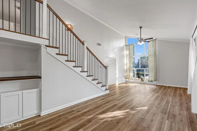 a view of a hallway with wooden floor and staircase