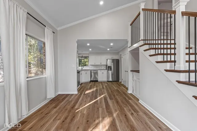 a view of a bedroom with wooden floor and stairs