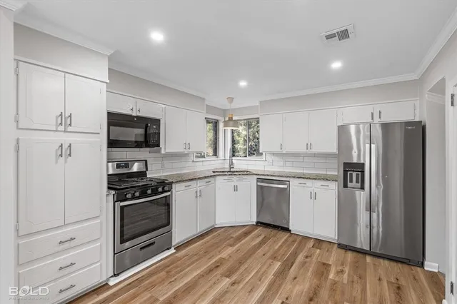 a kitchen with granite countertop a refrigerator stove and microwave