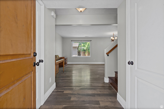 1346 Archmore Drive Springville, UT 84663 - Photo 8 of 32 Welcoming entry hall featuring wood-finish flooring, white baseboards, light gray walls, a partial staircase with wood handrail, and an overhead flush-mount light fixture