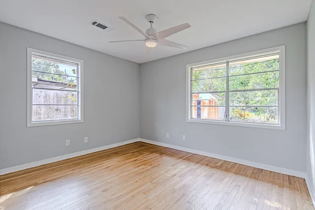 a view of a room with wooden floor and a window