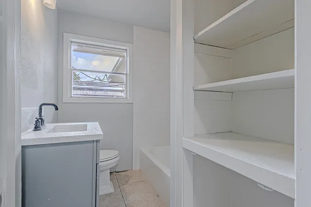 a bathroom with a toilet sink and mirror