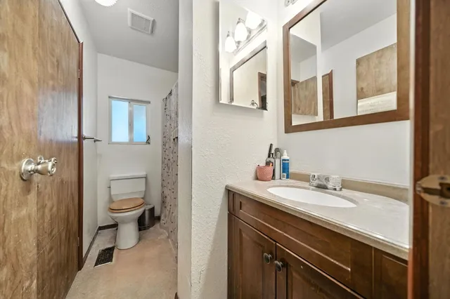 a bathroom with a sink a toilet and a mirror