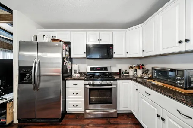 a kitchen with white cabinets and stainless steel appliances