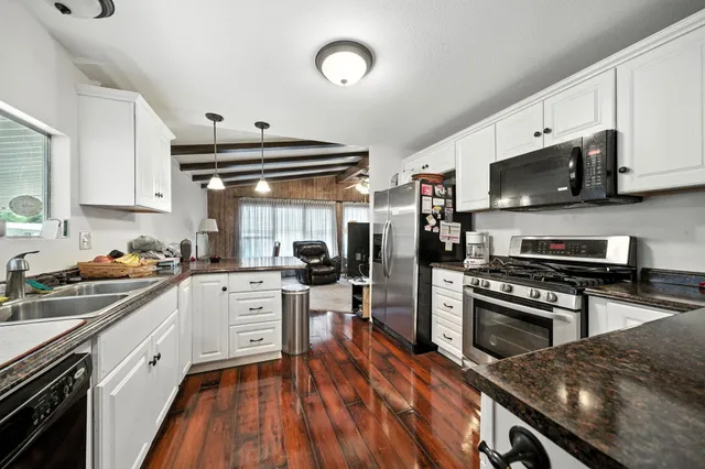 a kitchen with stainless steel appliances a stove a sink and a refrigerator
