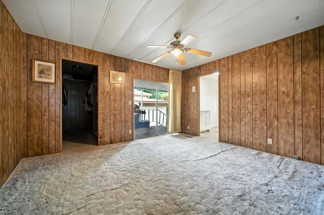 an empty room with fan and windows