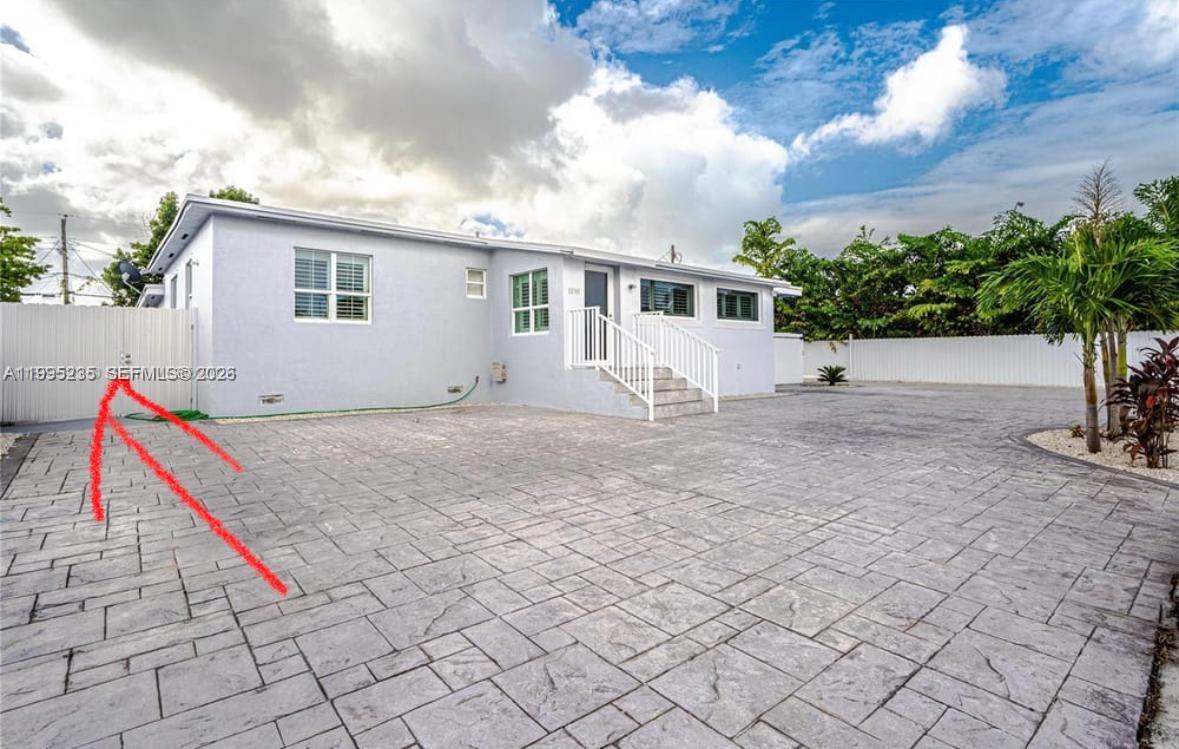 a view of house with backyard and bushes