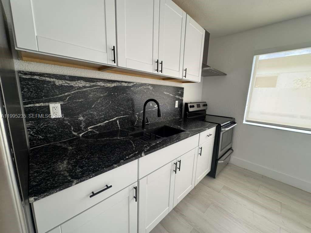230 East 56th Street, Unit A Hialeah, FL 33013 - Photo 17 of 25 a kitchen with granite countertop white cabinets and sink