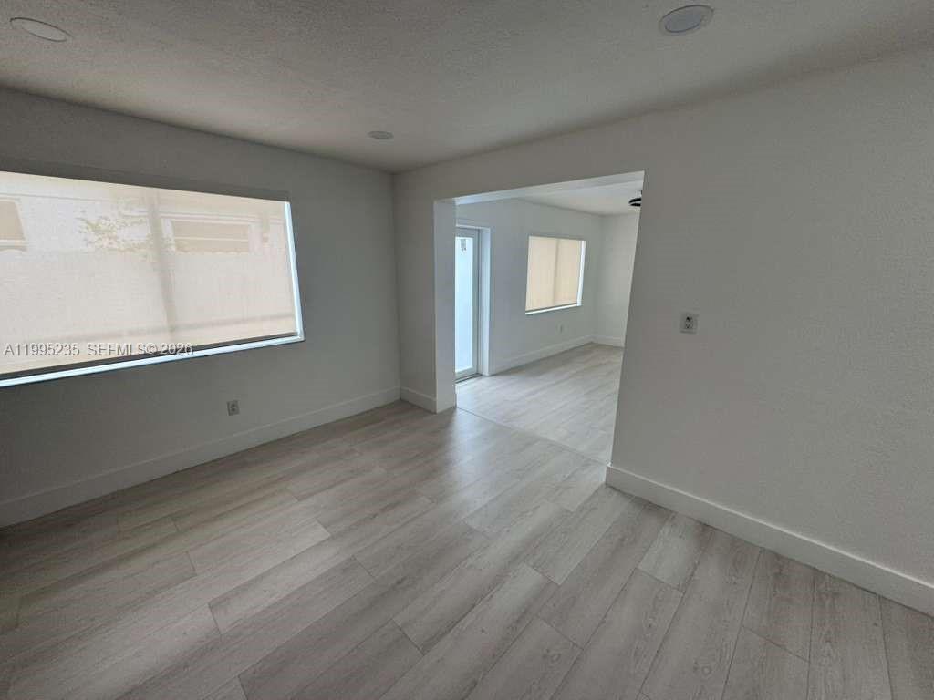 230 East 56th Street, Unit A Hialeah, FL 33013 - Photo 24 of 25 an empty room with wooden floor and windows