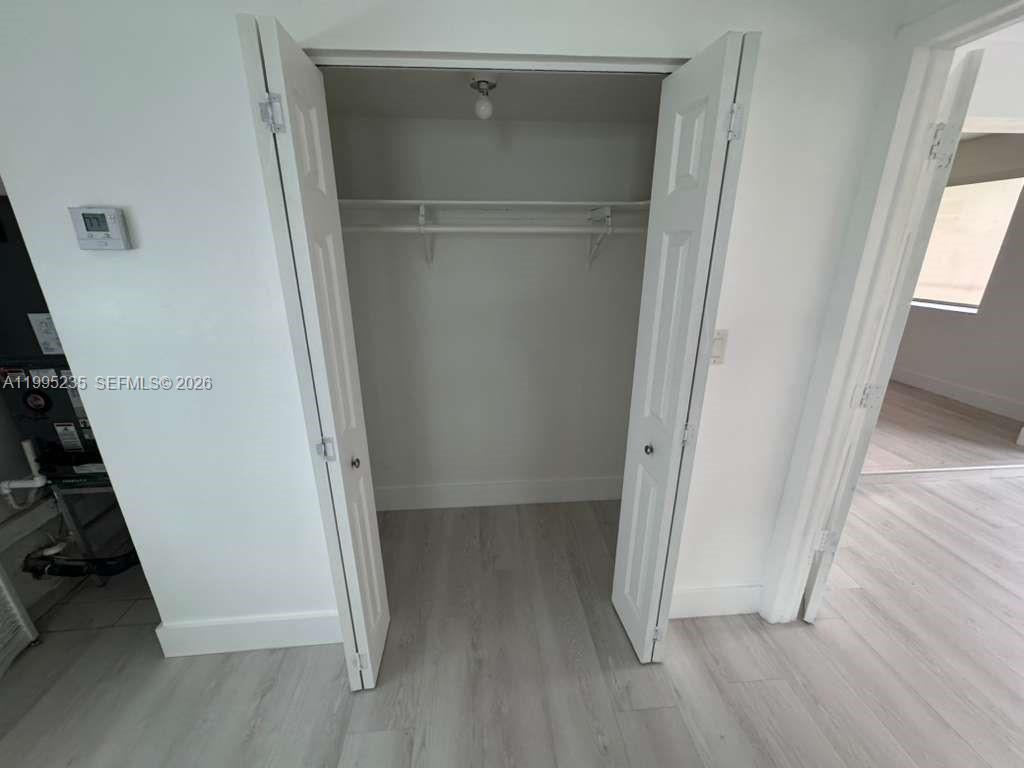 230 East 56th Street, Unit A Hialeah, FL 33013 - Photo 9 of 25 an empty room with wooden floor and white walls