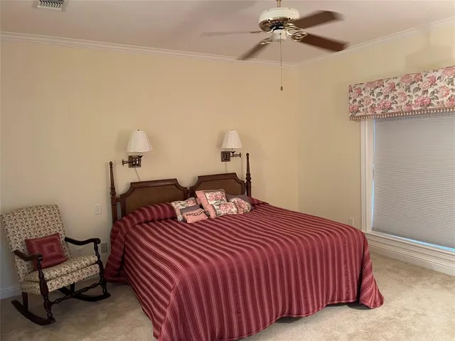 a bedroom with a bed and a lamp on the dresser