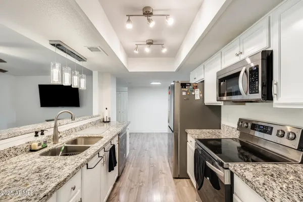 a kitchen with stainless steel appliances granite countertop a sink and a stove