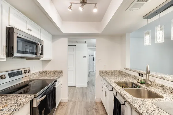 a kitchen that has a sink and a stove top oven