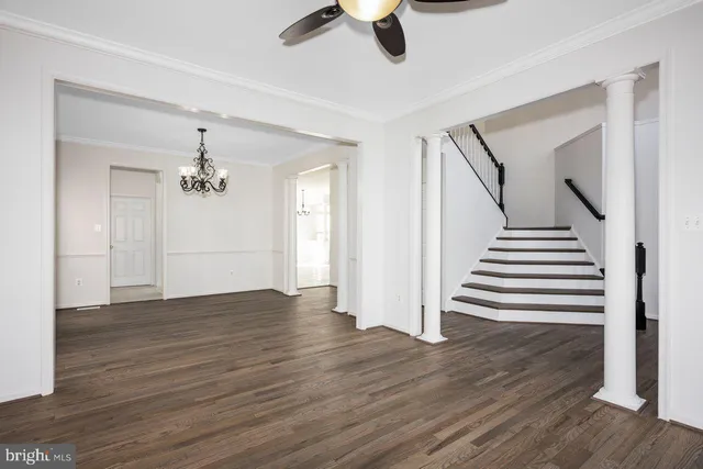 wooden floor in an empty room with a chandelier fan