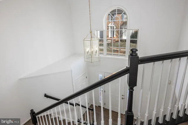 a view of a hallway with wooden floor windows and stairs