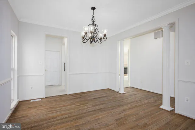 a view of empty room with wooden floor and ceiling fan