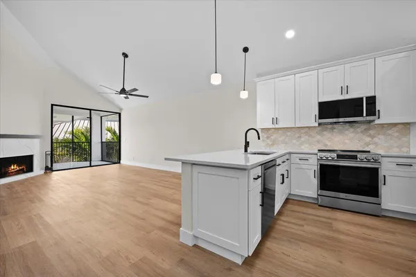 a kitchen with stainless steel appliances granite countertop a stove a sink and a microwave