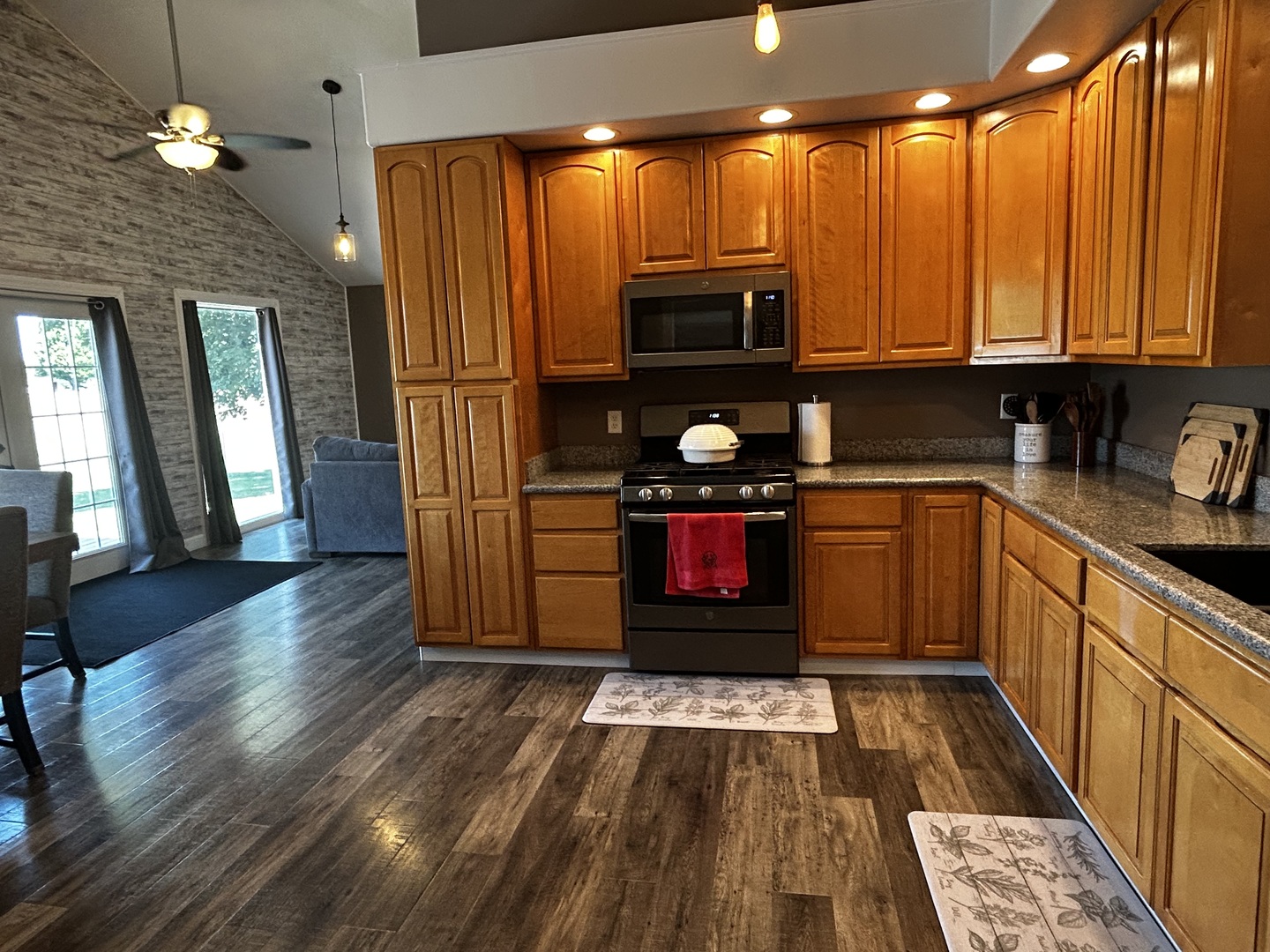 12795 Lawrence Road Sterling, IL 61081 - Photo 18 of 42 a kitchen with stainless steel appliances granite countertop a refrigerator a sink dishwasher a stove and white cabinets with wooden floor