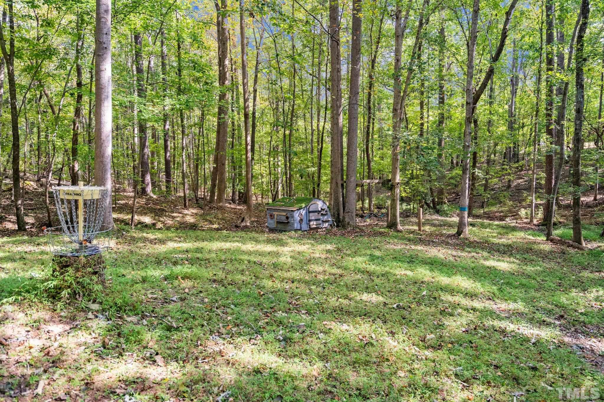 6509 Deerview Drive Raleigh, NC 27606 - Photo 30 of 36 a backyard of a house with lots of green space and fountain