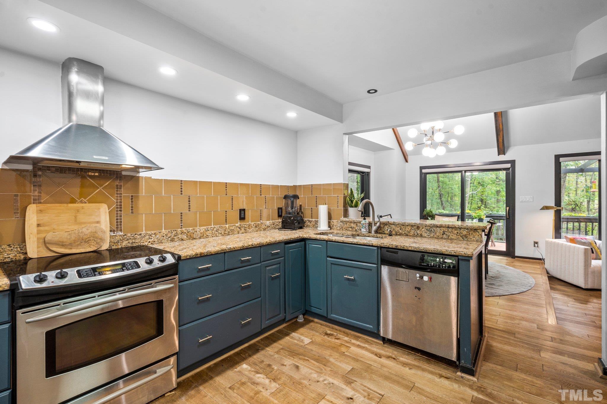 6509 Deerview Drive Raleigh, NC 27606 - Photo 10 of 36 a kitchen with stainless steel appliances granite countertop a stove a sink and a microwave