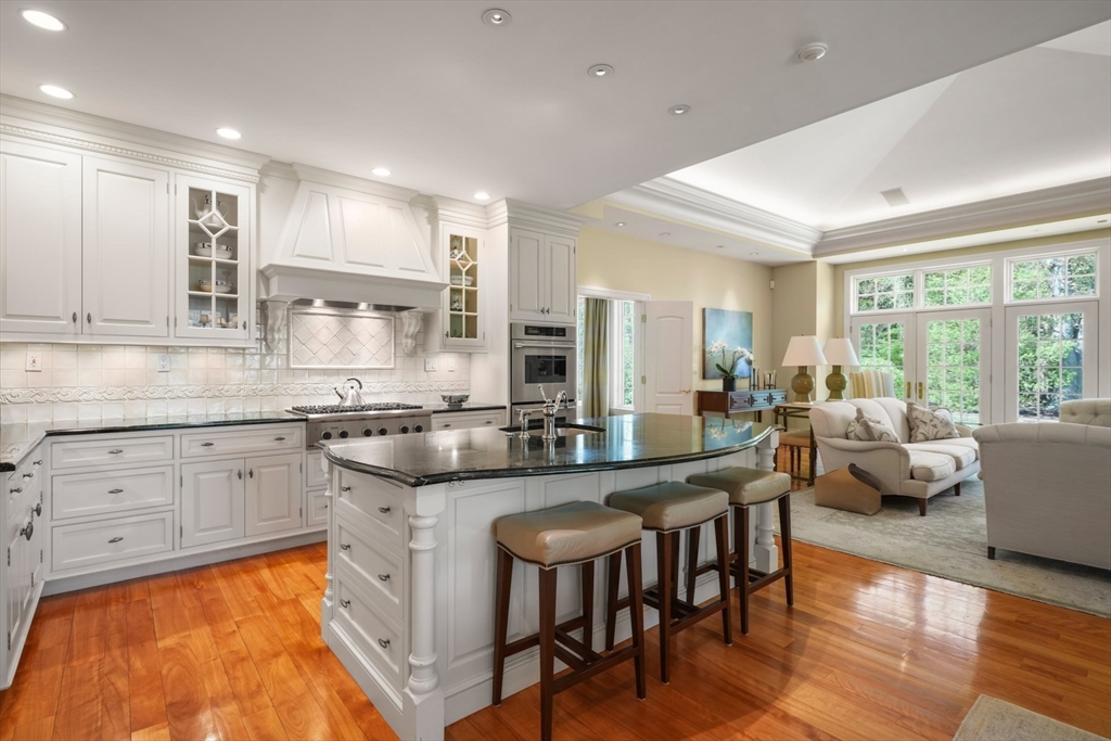 1 Old Farm Road Wellesley, MA 02481 - Photo 19 of 41 a kitchen with stainless steel appliances granite countertop a stove a sink dishwasher a couches and chairs with wooden floor