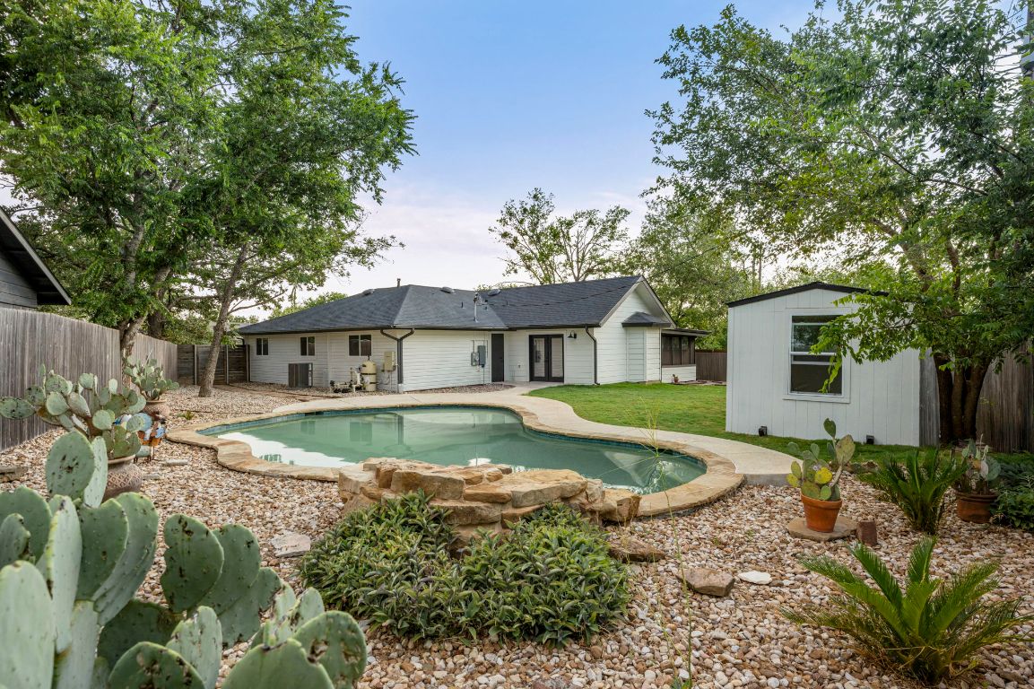 5702 Sutherlin Road Austin, TX 78723 - Photo 1 of 1 Back of property with a fenced backyard, xeriscape, and a pool