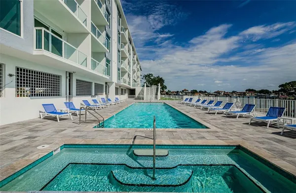 a view of a swimming pool with a yard and palm trees