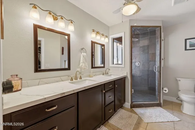 a bathroom with a double vanity sink mirror and toilet