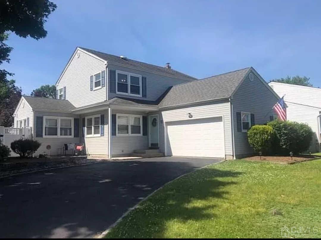 a front view of a house with a garden and yard