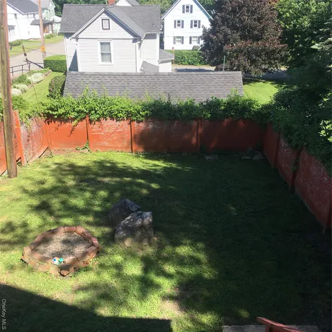 a front view of a house with a yard and lake view