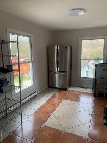 a view of empty room with window and refrigerator