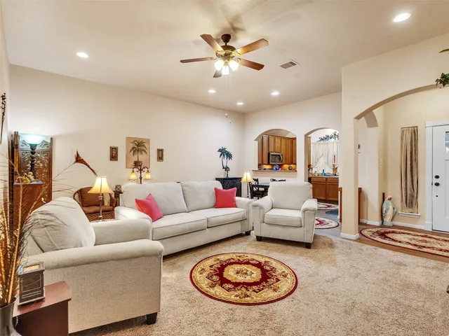 a living room with furniture a rug and white walls