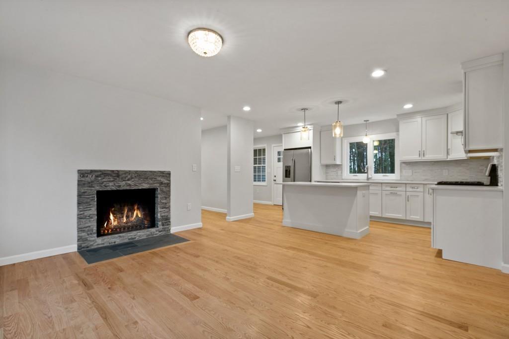 6 Sheffield Road Framingham, MA 01701 - Photo 11 of 32 a view of kitchen and empty room with wooden floor and fireplace