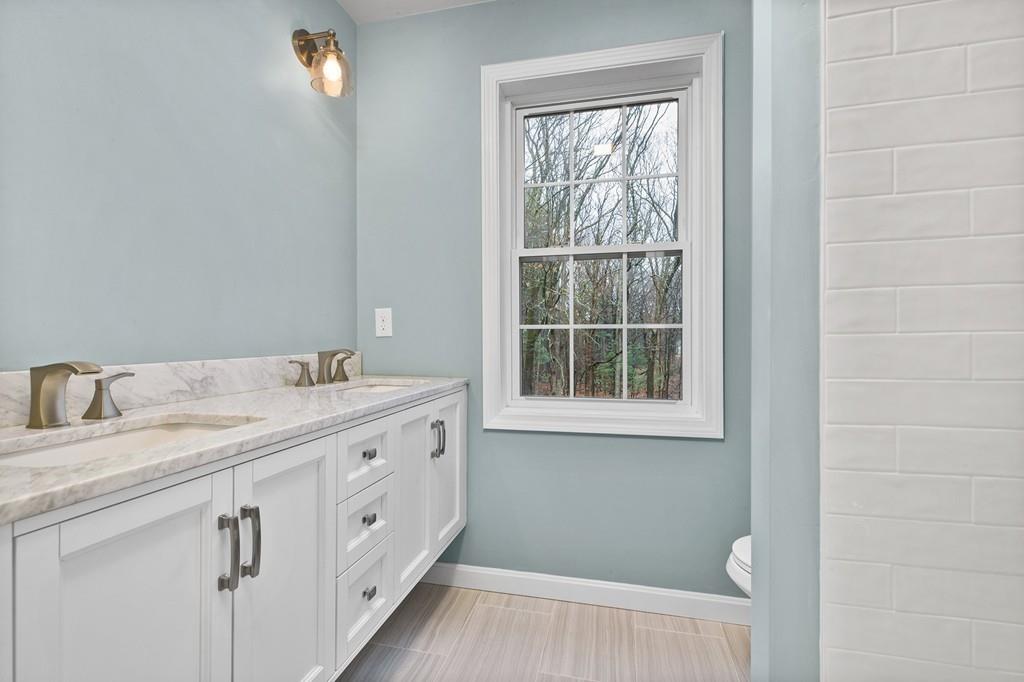 6 Sheffield Road Framingham, MA 01701 - Photo 26 of 32 a spacious bathroom with a granite countertop sink a toilet and a mirror