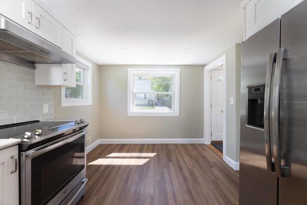 24 Endicott Road Stoneham, MA 02180 - Photo 4 of 15 a kitchen with a wooden floor and a stove top oven