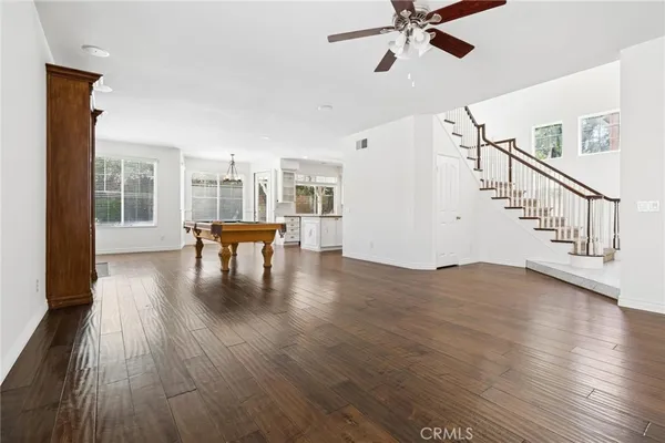 a living room with a table chairs and a kitchen view