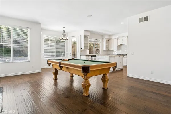 a dining room with wooden floor a ceiling fan and windows
