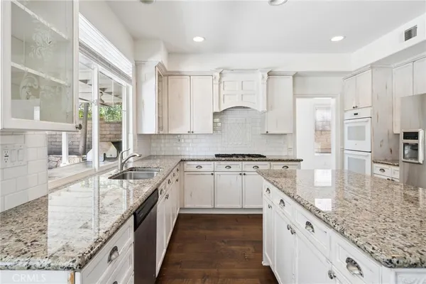 a kitchen with stainless steel appliances granite countertop a sink stove and cabinets