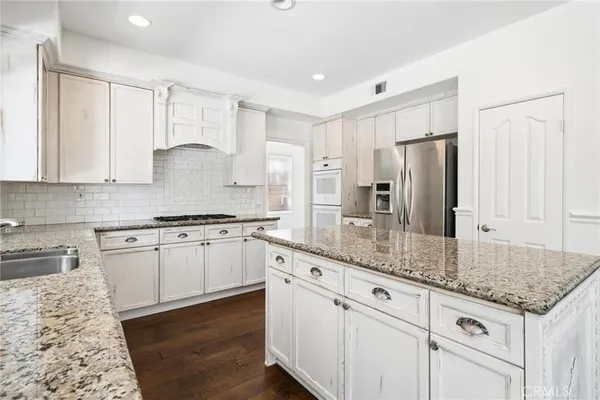 a kitchen with granite countertop a sink and a stove