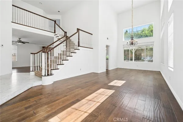 a view of empty room with wooden floor and windows