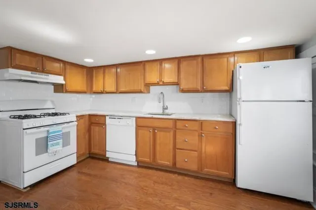 a kitchen with granite countertop white cabinets and white appliances